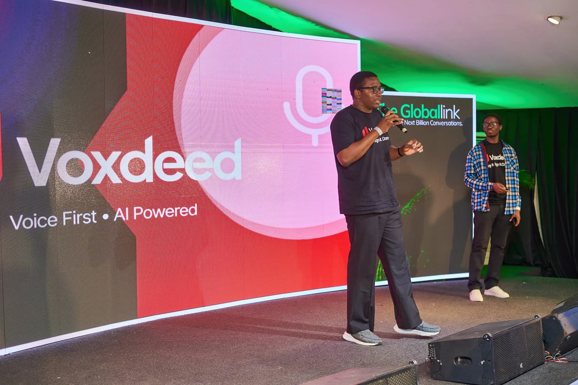 A founder pitching on stage in front of a large screen